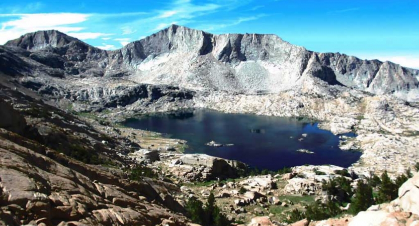 An alpine lake is framed by bare mountains of the high sierra